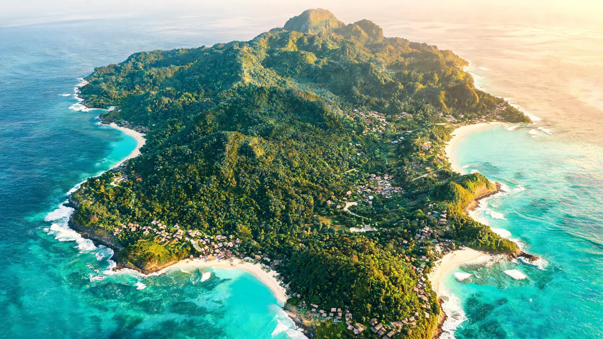 Vista aérea da ilha: mata fechada, praias de areia branca e pequenas vilas na costa